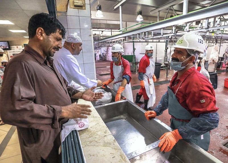 Abu Dhabi, U.A.E., August 22 , 2018.  Livestock shoppers for the second day of Eid Al Adha at the Abu Dhabi Livestock Market and the Abu Dhabi Public Slaughter House (Abu Dhabi Municipality) at the  Mina area.--  A customer instructs a slaughter house worker on what cut he wants for his livestock purchase.
Victor Besa/The National
Section:  NA
For:  stand alone and stock images