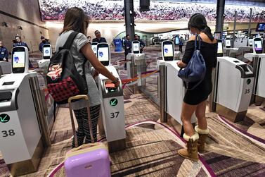 Passengers scan their passports at automated immigration gates at the newly-opened Changi International Airport's Terminal 4 in Singapore. Roslan Rahman / AFP