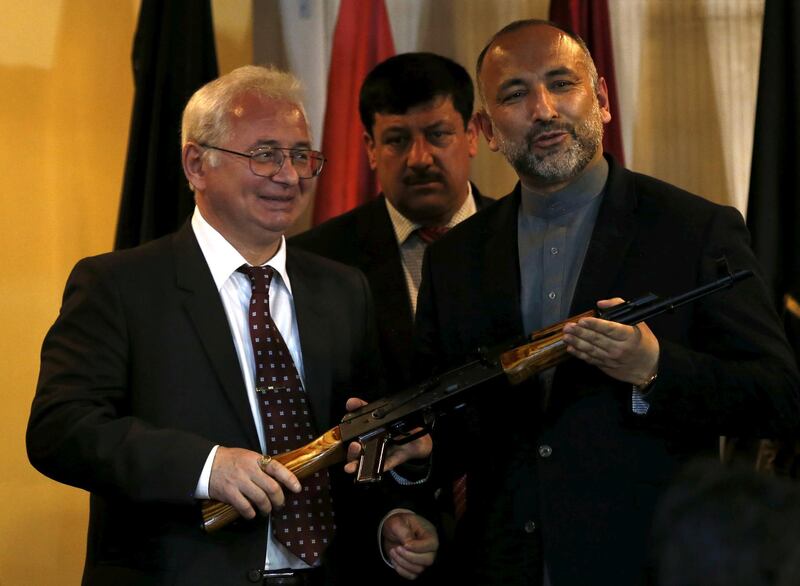 FILE PHOTO: Russia's ambassador, to Afghanistan Alexander Mantytskiy (L) hands over an AK-47 to Afghan national security adviser Hanif Atmar (R) after a conference at the International Kabul Airport, Afghanistan February 24, 2016. REUTERS/Mohammad Ismail/File Photo