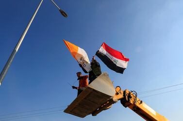 Christians volunteers hold Iraqi and Vatican flags as they decorate streets ahead of the planned visit of Pope Francis, in Qaraqosh, Iraq February 22, 2021. Picture taken February 22, 2021. REUTERS/Thaier al-Sudani