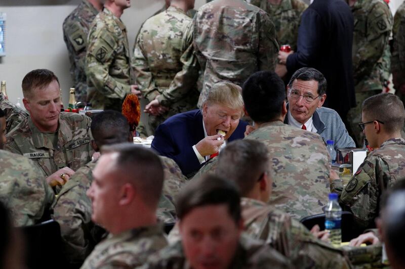 U.S. President Donald Trump eats dinner with US troops.  AP