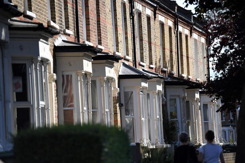 (FILES) In this file photo taken on August 13, 2017 Pedestrians walk past a row of terraced houses in London. Prices down, paralyzed transactions and depressed agents: Brexit has had a chilling effect on British real estate, particularly in London. "The market is at a standstill," says Beatrice Caboche, director of the real estate company Barnes UK. House prices across the country are stagnant: they grew by only 0.7% year on year in July, their slowest pace since the end of 2012. / AFP / Chris J Ratcliffe
