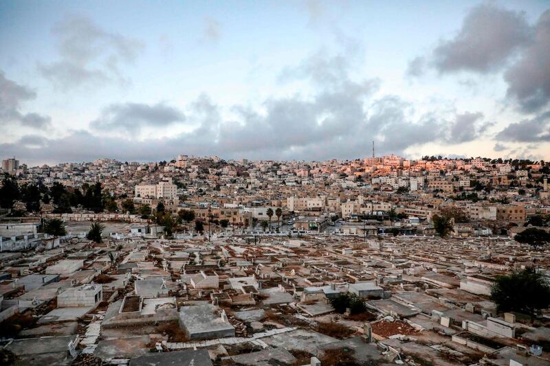 The flashpoint city of Hebron in the occupied West Bank shows a view of a Palestinian cemetery (foreground), an old market building (C) along al-Shuhada street that was newly-announced by the Israeli defence minister to be designated as a new settlement, with existing Israeli settler buildings behind.  AFP