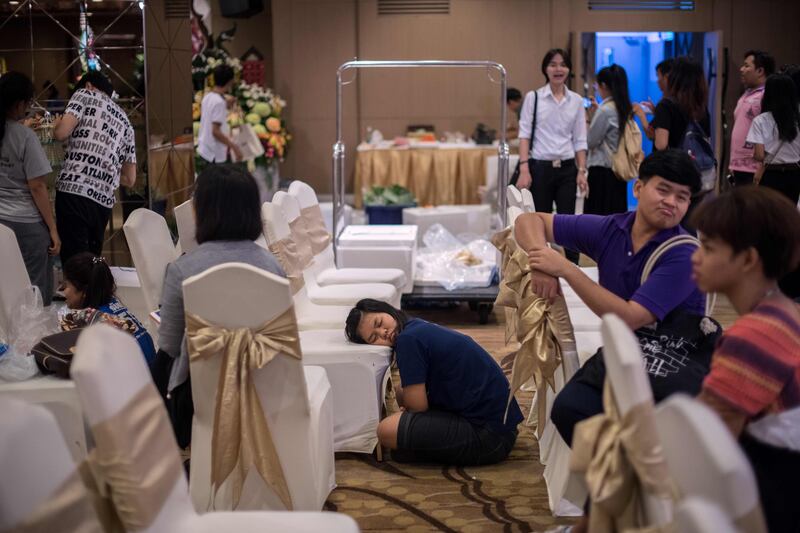 A girl sleeps on a chair as others put together elaborate fruit and vegetable displays during a fruit and vegetable carving competition in Bangkok. Robert Schmidt / AFP
