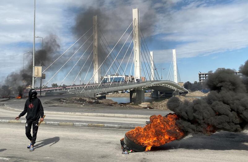 Demonstrators block the road with burning tires during ongoing anti-government protests in Nassiriya, Iraq. REUTERS