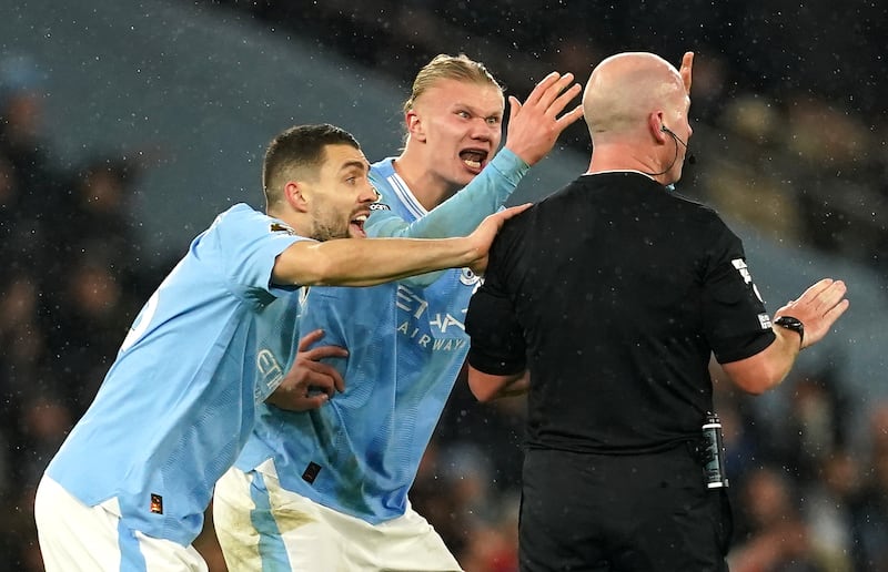 Erling Haaland, centre, was incensed by referee Simon Hooper's decision to award a free kick when the Manchester City striker had passed to a teammate in a position to score late on against Tottenham on Sunday. PA