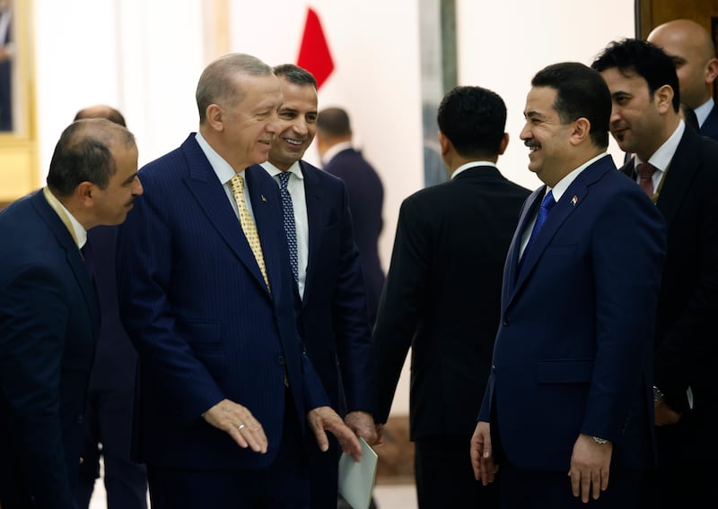 Mr Erdogan and Mr Al Sudani share a lighter moment, during the signing of the memorandum of understanding between Iraq, Turkey, Qatar and the UAE. AP