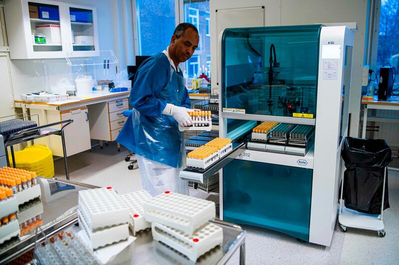 Medical staff at the laboratory of the Karolinska Hospital operates a machine used in the PCR testing process in Solna near Stockholm, Sweden. AFP