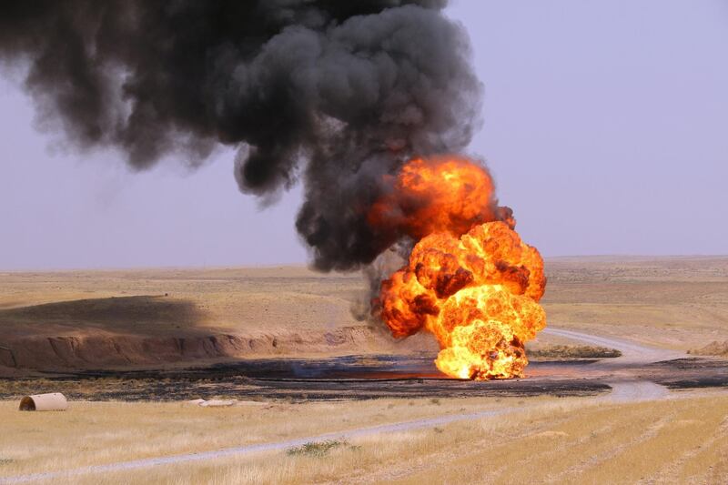 A picture taken on August 10, 2016 shows flames and smoke rising from a well on fire at Bai Hassan oil field, the largest in Iraqi oil-rich Kirkuk province. - The explosion of an improvised explosive device (IED) set fire to one of the wells at Bai Hassan according to a police lieutenant colonel and an official from the North Oil Company. (Photo by Marwan IBRAHIM / AFP)