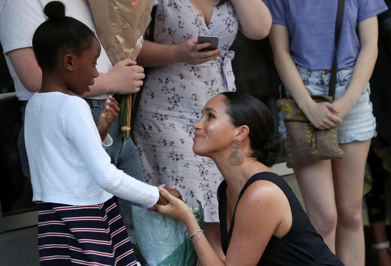 The royal greets a girl outside the organisation's headquarters. Reuters