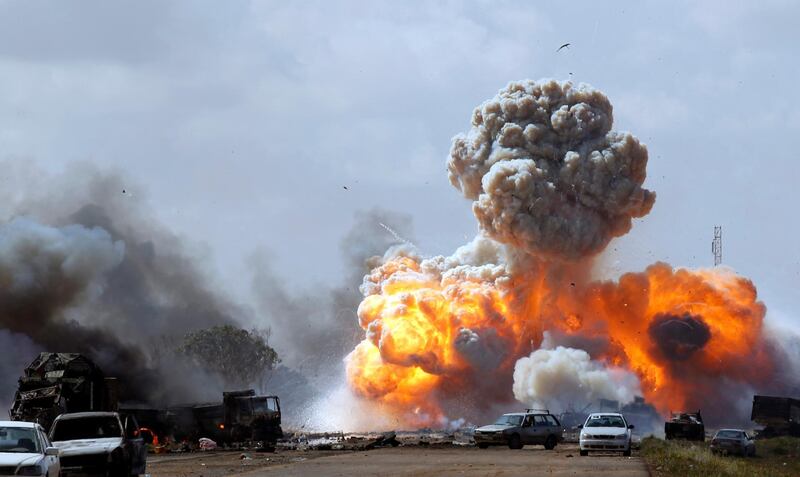 Vehicles belonging to forces loyal to Libyan leader Muammar Gaddafi explode after an air strike by coalition forces, along a road between Benghazi and Ajdabiyah March 20, 2011. REUTERS/Goran Tomasevic (LIBYA - Tags: POLITICS CIVIL UNREST CONFLICT IMAGES OF THE DAY) FOR BEST QUALITY IMAGE SEE: GM1E7AS06KN01