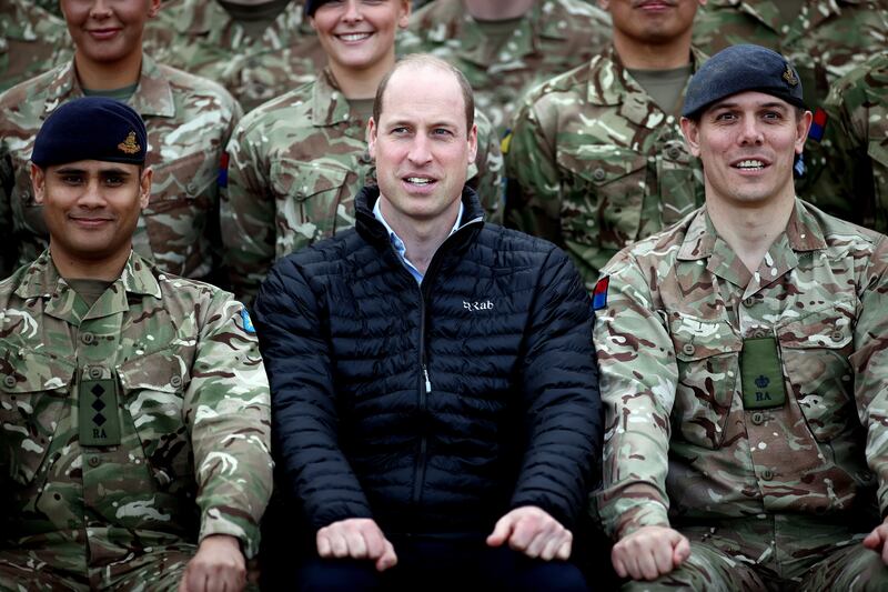 Prince William poses for a photo with soldiers during a visit to the British military base in Jasionka. EPA