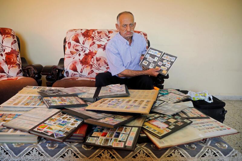 Palestinian man Mahmoud Kayed displays postage stamps which he collected over decades, in the town of Sebastia near Nablus in the Israeli-occupied West Bank. Reuters