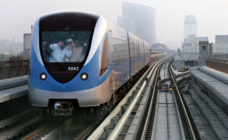 DUBAI, UNITED ARAB EMIRATES - SEPTEMBER 10:  Passengers wave from a passing train seen from on board the first train of the day on the Dubai Metro network which pulled out of the Nakheel  Harbour & Tower station at 6am in Dubai on September 10, 2009. Ten metro stations on the Red Line officially opened to the public this morning.  (Randi Sokoloff / The National)  For news story by Jonathan Gornall/Stock- Dubai Metro
