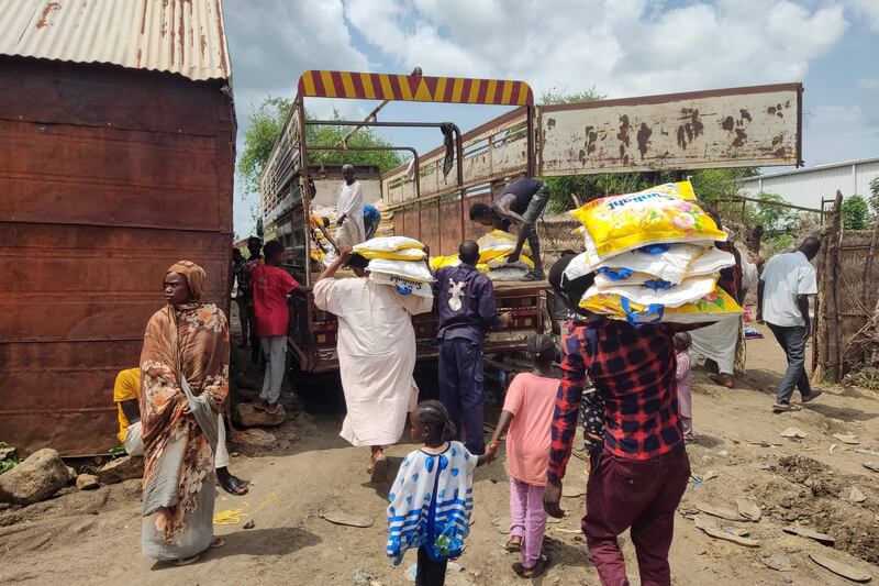 Men load Ethiopian products onto a truck in Sudan's border town of Gallabat on August 2. Photo: AFP