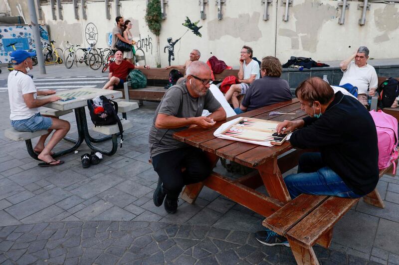 People relax in the Israeli coastal city of Tel AViv on April 19, 2021, after authorities announced that face masks for COVID-19 prevention were no longer needed outside. With more than half of the population fully vaccinated in one of the world's fastest COVID-19 inoculation campaigns, the number of coronavirus cases in Israel fell from some 10,000 new infections per day in mid-January to about 200 cases per day, which triggered an announcement from the Health Department on April 15 that face masks are no longer mandatory outdoors. / AFP / menahem kahana
