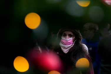 A woman wears a face covering as she walks past a Christmas Lights decoration in London, Wednesday, Dec.  22, 2021.  British Prime Minister Boris Johnson said on Monday that his government reserves the "possibility of taking further action" to protect public health as Omicron spreads across the country.  (AP Photo / Frank Augstein)