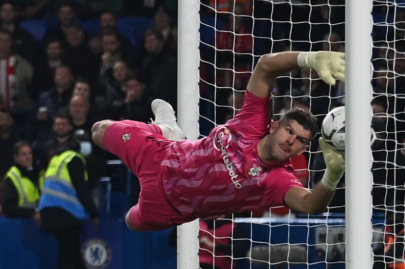 The ball beats Southampton's English goalkeeper Fraser Forster for Cheslea's first goal scored by Chelsea's German midfielder Kai Havertz (unseen) during the English League Cup round of 16 football match between Chelsea and Southampton at Stamford Bridge in London on October 26, 2021.  (Photo by Glyn KIRK / AFP) / RESTRICTED TO EDITORIAL USE.  No use with unauthorized audio, video, data, fixture lists, club/league logos or 'live' services.  Online in-match use limited to 120 images.  An additional 40 images may be used in extra time.  No video emulation.  Social media in-match use limited to 120 images.  An additional 40 images may be used in extra time.  No use in betting publications, games or single club/league/player publications.   /  