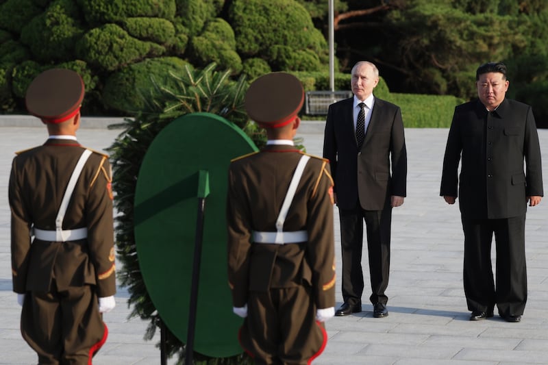 Mr Putin and Mr Kim attend a wreath-laying ceremony at Liberation Monument in Pyongyang. EPA / Sputnik