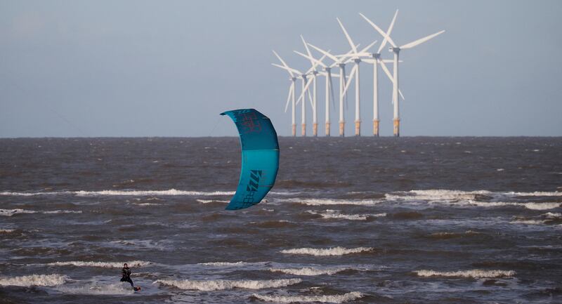 A kite-surfer rides the waves in front of the Burbo Bank offshore wind farm near Wallasey, Britain. Reuters