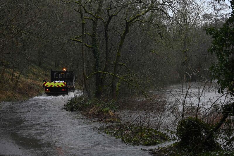 An emergency vehicle drives down a flooded road as the river Wye has burst its banks near Great Longstone. AFP