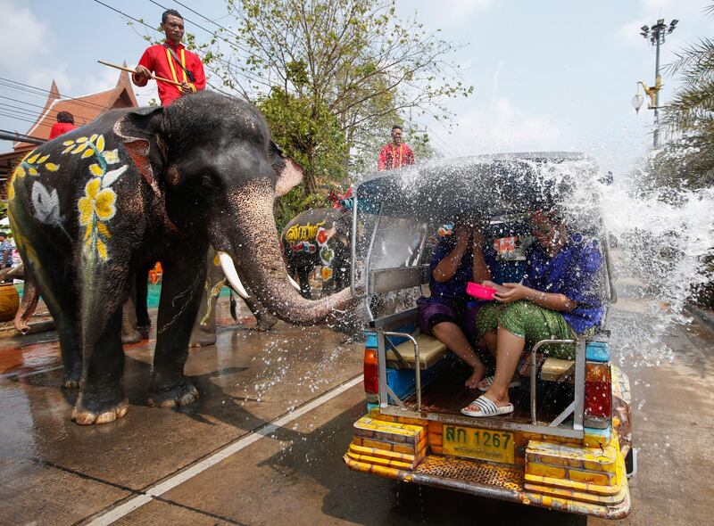A Thai mahout rides on elephant spraying water on revelers in a Tuk Tuk during the Songkran Festival in the city of Ayutthaya, Thailand. EPA