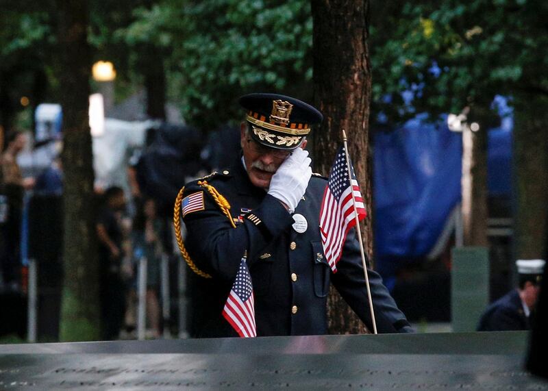 A guest wipes a tear among names at the edge of the south reflecting pool at the National 9/11 Memorial and Museum. Reuters
