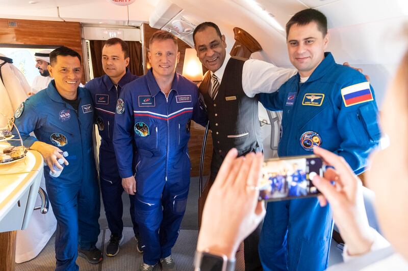 Nasa astronauts and Russian cosmonauts pose for a photo with an Emirates employee