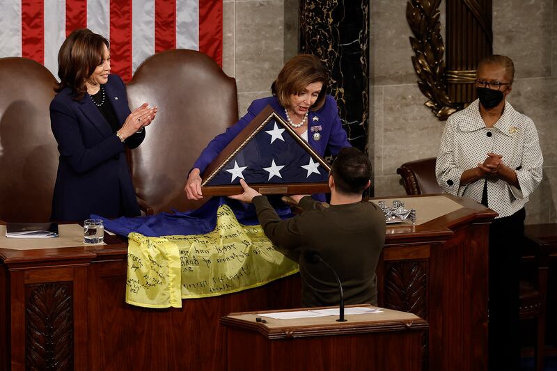 Ms Pelosi gives a US flag to Mr Zelenskyy. AFP