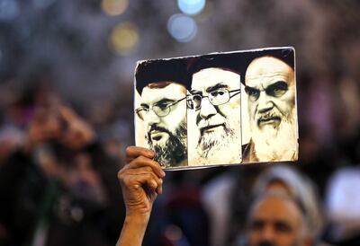 A man holds a placard depicting former Iranian supreme leader Ayatollah Ruhollah Khomeini (R), current Iranian supreme leader Ayatollah Ali Khamenei (C) and Hezbollah leader Hassan Nasrallah (L) in Tehran. EPA