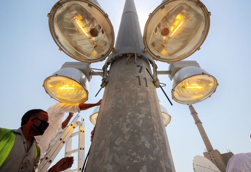 Technicians with the Ministry of Electricity and Water carry out maintenance work on street lights in Kuwait City. AFP