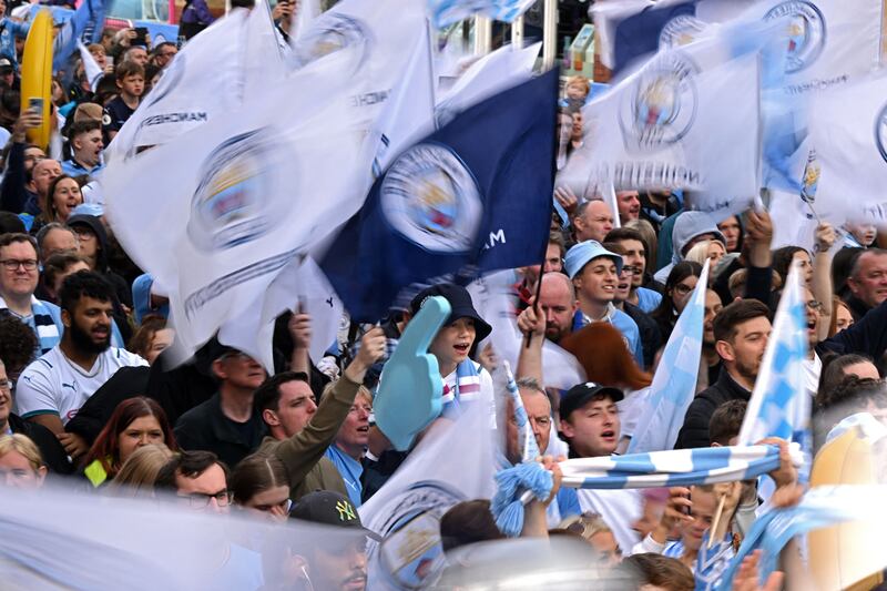 Manchester City fans wait for the open-top bus parade to start. AFP. 