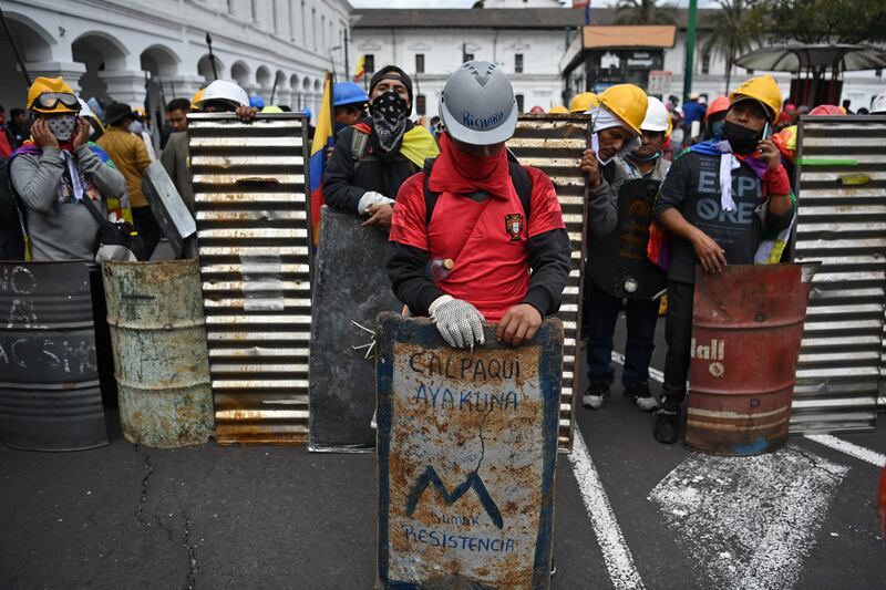 Indigenous people stand with makeshift shields at Santo Domingo Square, Quito, as nationwide protest against high living costs continue across Ecuador. AFP