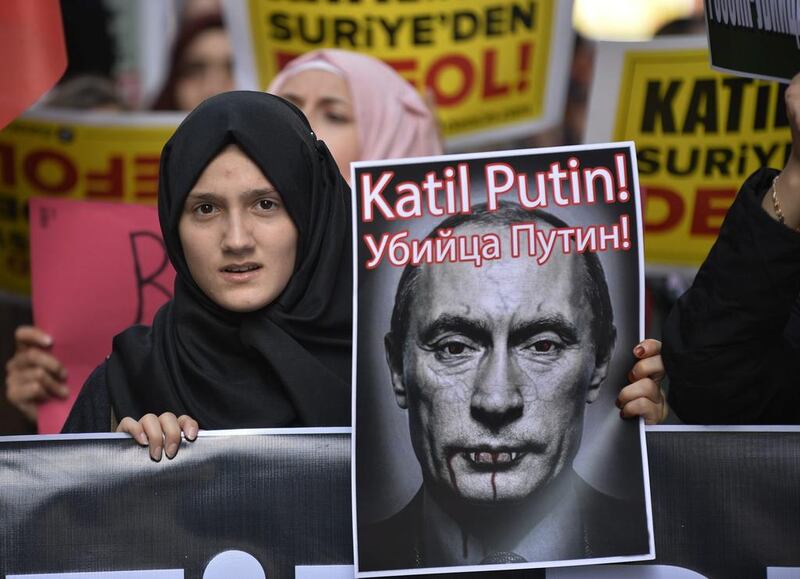 A demonstrator holds a picture depicting Russian president Vladimir Putin during a protest against Russian military operations in Syria, in Istanbul, Turkey. The picture reads both in Turkish and Russian: ‘Murderer Putin’, as Moscow ramps up its military involvement in Syria’s civil war. AP Photo