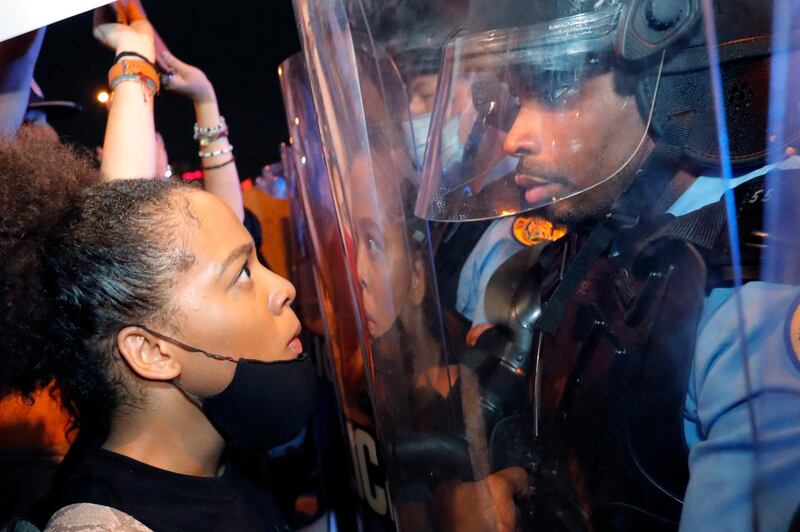 A protester and a police officer stare at one another on the Crescent City Connection bridge, which spans the Mississippi River in New Orleans, during a protest over the May 25 death of George Floyd, who died after being restrained by police in Minneapolis. AP Photo