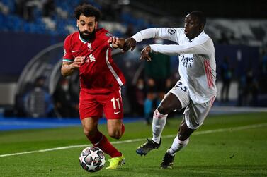 Real Madrid's French defender Ferland Mendy (R) challenges Liverpool's Egyptian midfielder Mohamed Salah during the UEFA Champions League first leg quarter-final football match between Real Madrid and Liverpool at the Alfredo di Stefano stadium in Valdebebas in the outskirts of Madrid on April 6, 2021. / AFP / GABRIEL BOUYS