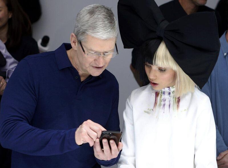 Apple CEO Tim Cook shows singer Sia an iPhone 7.  Beck Diefenbach / Reuters