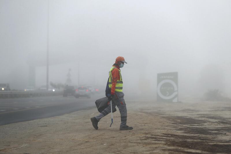 Dubai, United Arab Emirates - Reporter: N/A. News. A gentleman collects rubbish on the side of the road in the fog. Thursday, April 8th, 2021. Dubai. Chris Whiteoak / The National