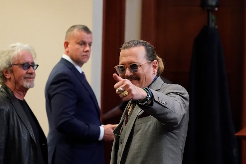 Depp gestures towards his fans in the courtroom. AP