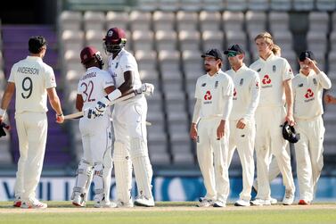 Cricket - First Test - England v West Indies - Rose Bowl Cricket Stadium, Southampton, Britain - July 12, 2020 West Indies' John Campbell and Jason Holder celebrate winning the test as England's Rory Burns and teammates look on dejected, as play resumes behind closed doors following the outbreak of the coronavirus disease (COVID-19) Adrian Dennis/Pool via REUTERS