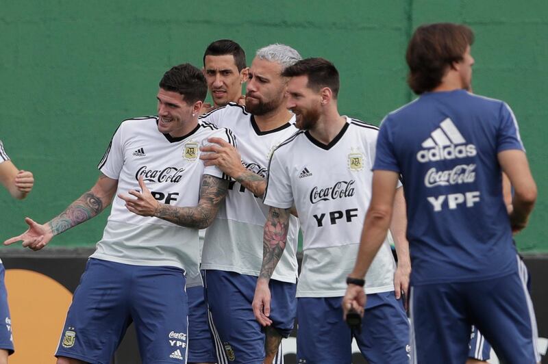 Rodrigo De Paul, left, Otamendi, centre, and Messi have a fun moment during training. AP Photo