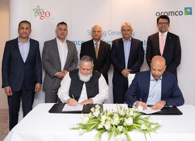 Yasser Mufti, seated right, Aramco’s executive vice president of products and customers, signs the agreement with GO founder and chief executive Khalid Riaz, seated left. Photo: Aramco