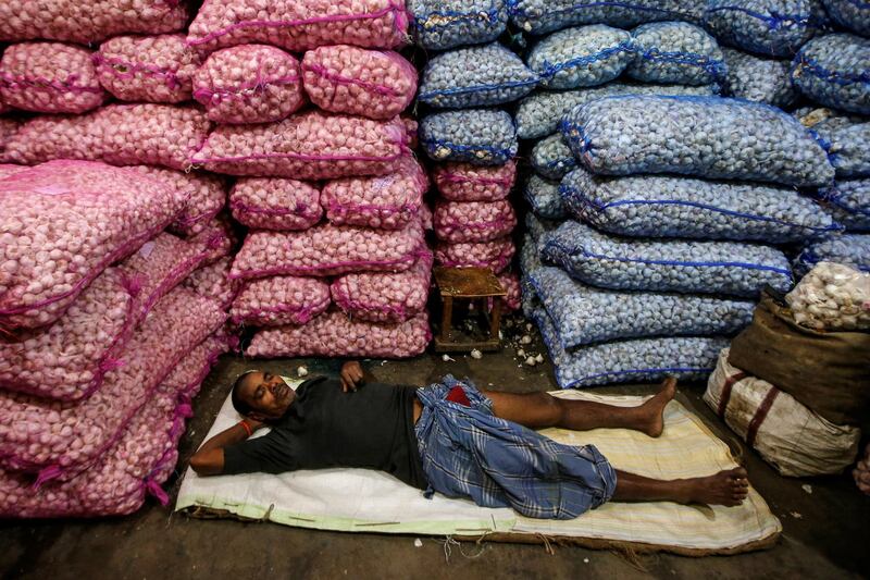 A labourer sleeps at a wholesale vegetable market early morning in Kolkata, India. Reuters