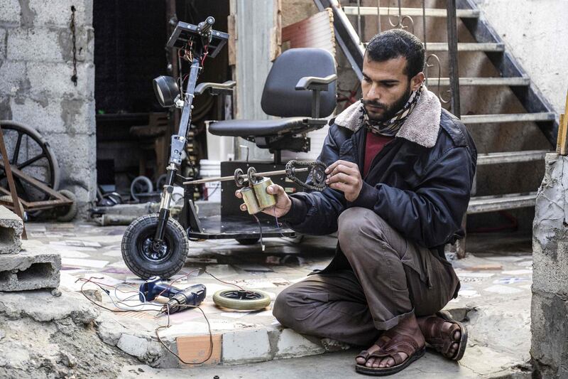 Abu Raida assembles an electric vehicle at his workshop. AFP