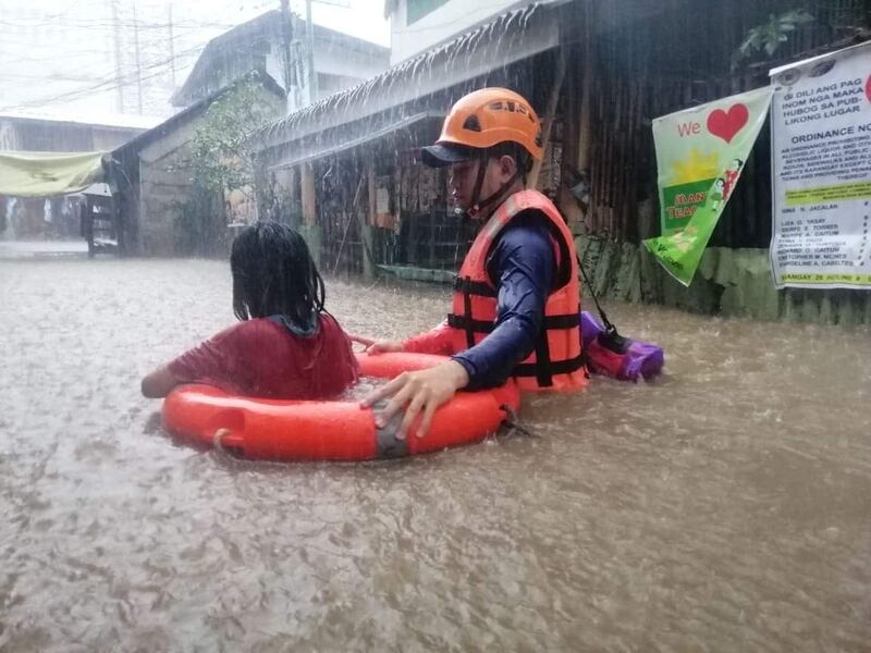 A Philippine Coast Guard helps a resident in Typhoon Rai in Cagayan De Oro. Photo: Reuters