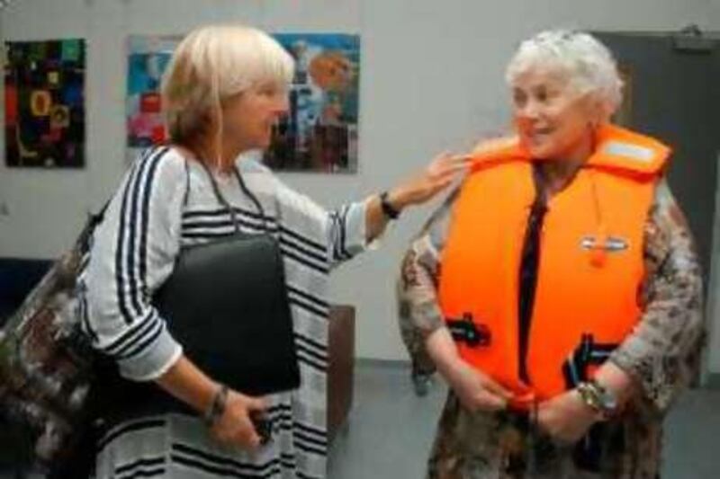 Angela Godfrey-Goldstein (L) talks to fellow volunteer Mary Hughes-Thompson as the latter tries on a life vest at the temporary offices of the US-based Free Gaza Movement in Nicosia, Cyprus on August 6, 2008. The two women are among mostly British and US activists hoping to break the blockade of the poverty-stricken Palestinian territory of the Gaza Strip from the sea soon. Two boats carrying 40 activists, including Jewish and Arab Israelis, are set to sail from the east Mediterranean island in a bid to break the siege, but organisers are keeping the logistics to themselves for security reasons. AFP PHOTO/STEFANOS KOURATZIS *** Local Caption ***  012187-01-08.jpg *** Local Caption ***  012187-01-08.jpg