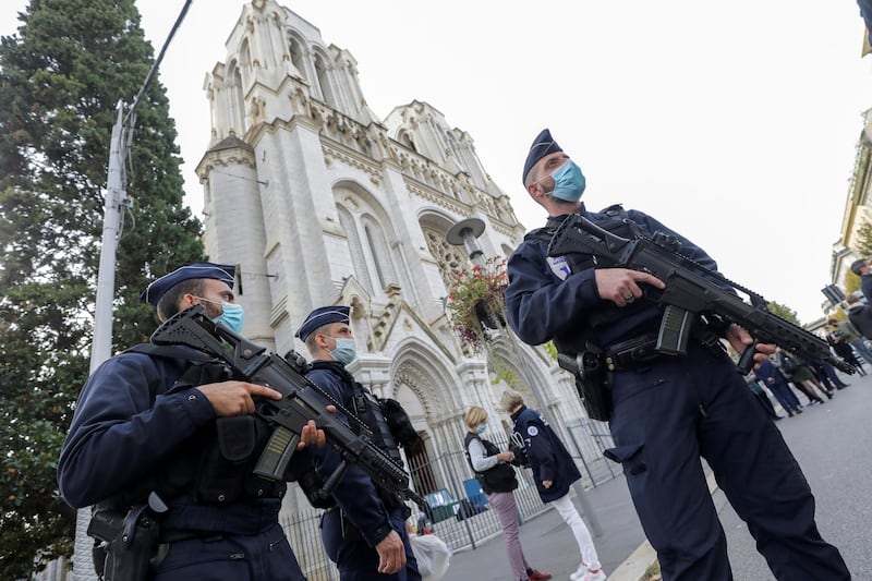 French police officers stand near Notre Dame church in Nice, southern France, Thursday, Oct. 29, 2020. French President Emmanuel Macron has announced that he will more than double number of soldiers deployed to protect against attacks to 7,000 after three people were killed at a church Thursday. (Eric Gaillard/Pool via AP)
