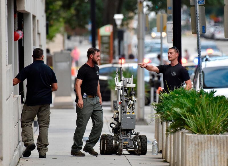 Bomb squad police prepare a robot to enter a parking garage a block away from the scene of a multiple shooting at the Jacksonville Landing. AP Photo