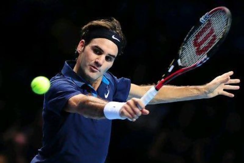 Roger Federer of Switzerland plays a backhand volley in a match against Jo-Wilfried Tsonga of France during the ATP World Tour Finals tennis tournament in London on November 2011.