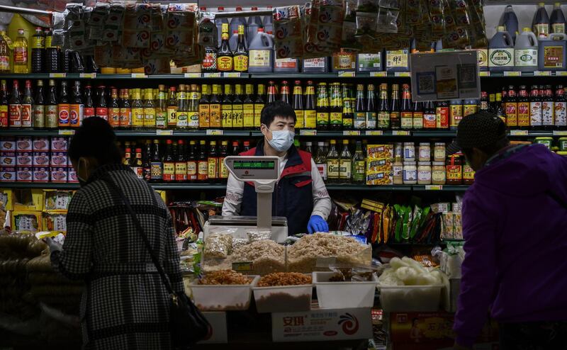 BEIJING, CHINA - APRIL 24: A Chinese vendor wears a protective mask as he stands in front of sauces for sale at a food market on April 24, 2020 in Beijing, China. After decades of growth, officials said Chinas economy had shrunk in the latest quarter due to the impact of the coronavirus epidemic. The slump in the worlds second largest economy is regarded as a sign of difficult times ahead for the global economy. While industrial sectors in China are showing signs of reviving production, a majority of private companies are operating at only 50% capacity, according to analysts. With the pandemic hitting hard across the world, officially the number of coronavirus cases in China is dwindling, ever since the government imposed sweeping measures to keep the disease from spreading. Officials believe the worst appears to be over in China, though there are concerns of another wave of infections as the government attempts to reboot the worlds second largest economy. Since January, China has recorded more than 81,000 cases of COVID-19 and at least 3200 deaths, mostly in and around the city of Wuhan, in central Hubei province, where the outbreak first started. (Photo by Kevin Frayer/Getty Images)